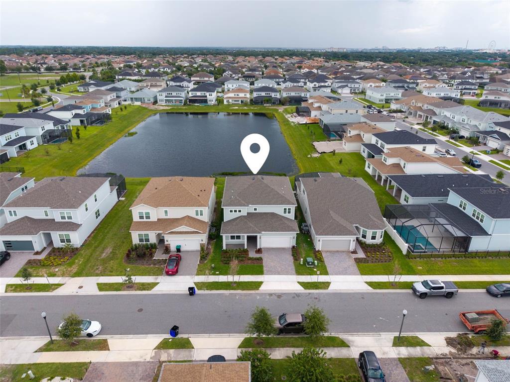 An aerial view shows a two-story suburban house with a backyard facing a pond — 8369 FENTON STREET, ORLANDO, FL