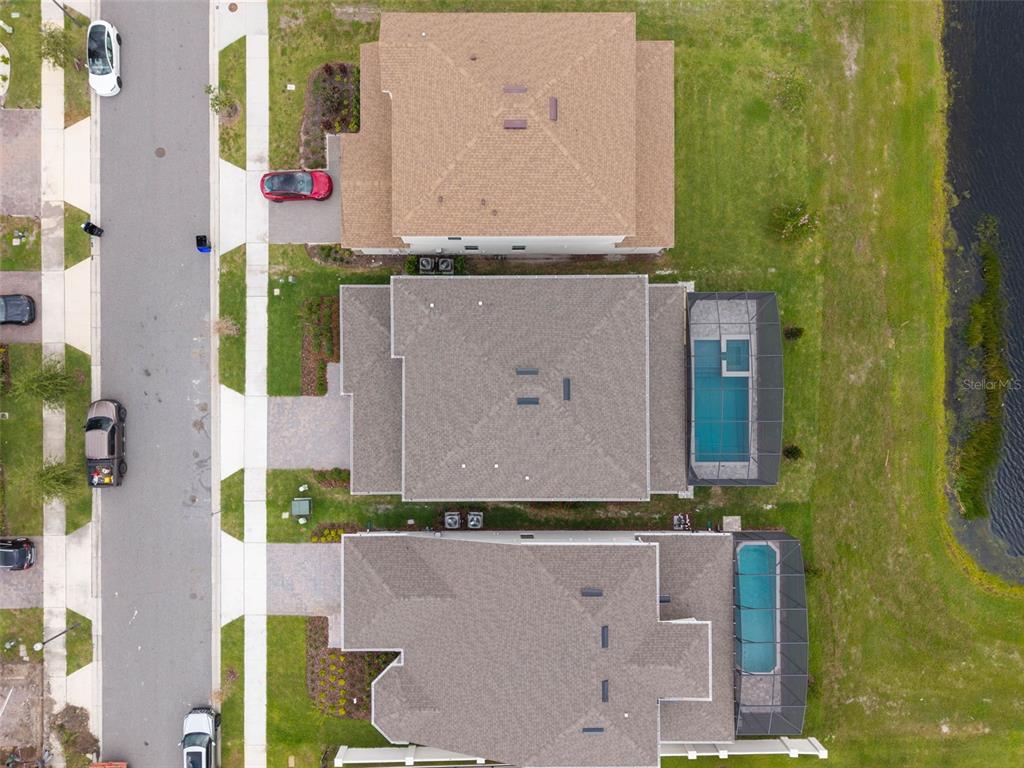 An aerial view shows three suburban houses with pools, driveways, and a nearby pond — 8369 FENTON STREET, ORLANDO, FL