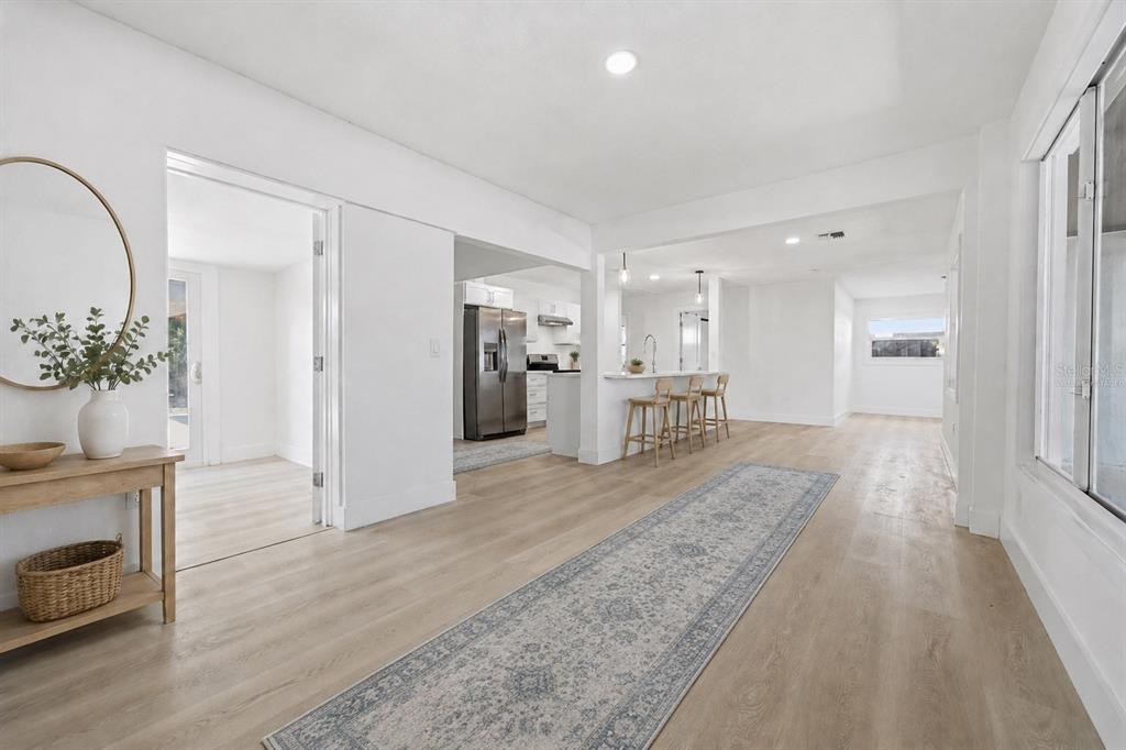 A modern kitchen features white cabinetry, stainless steel appliances, and a large white quartz island — 2317 GROVE STREET, SARASOTA, FL