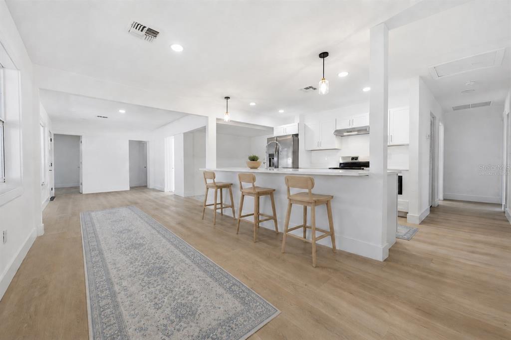 A modern kitchen features white cabinets, a large island with a sink, and stainless appliances — 2317 GROVE STREET, SARASOTA, FL