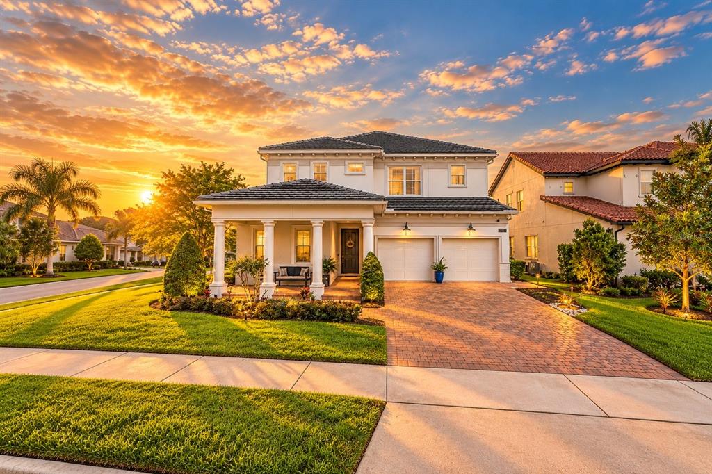 An aerial view of a suburban neighborhood featuring houses with tiled roofs near a lake — 15161 CANOE PLACE, WINTER GARDEN, FL