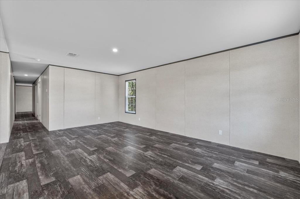 An empty room with light-colored paneled walls, dark wood-look flooring, and a single window — 2763 N VASSER TERRACE, HERNANDO, FL
