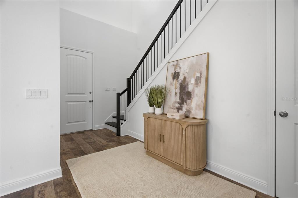 A staircase with dark wood treads and a black metal railing leads to an upper level — 15730 VETTA DRIVE, MONTVERDE, FL