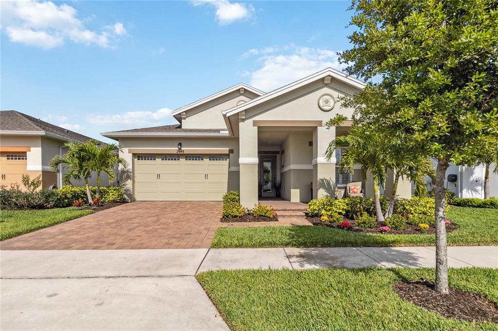A single-story house with a beige stucco exterior, a two-car garage, and a paved driveway — 2748 GREENLANDS STREET, ST CLOUD, FL