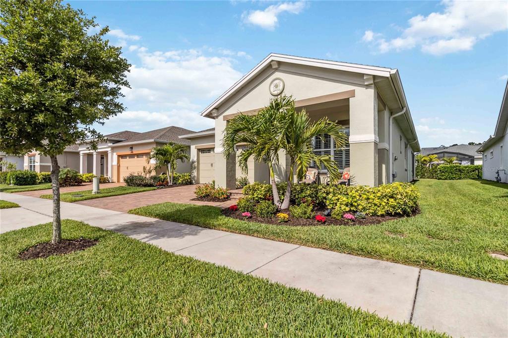 A single-story suburban house with a covered front porch, palm trees, and a paved driveway — 2748 GREENLANDS STREET, ST CLOUD, FL