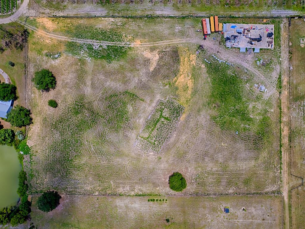 An aerial view shows a large, cleared rectangular lot with a small foundation and equipment — 12005 SR-33, GROVELAND, FL