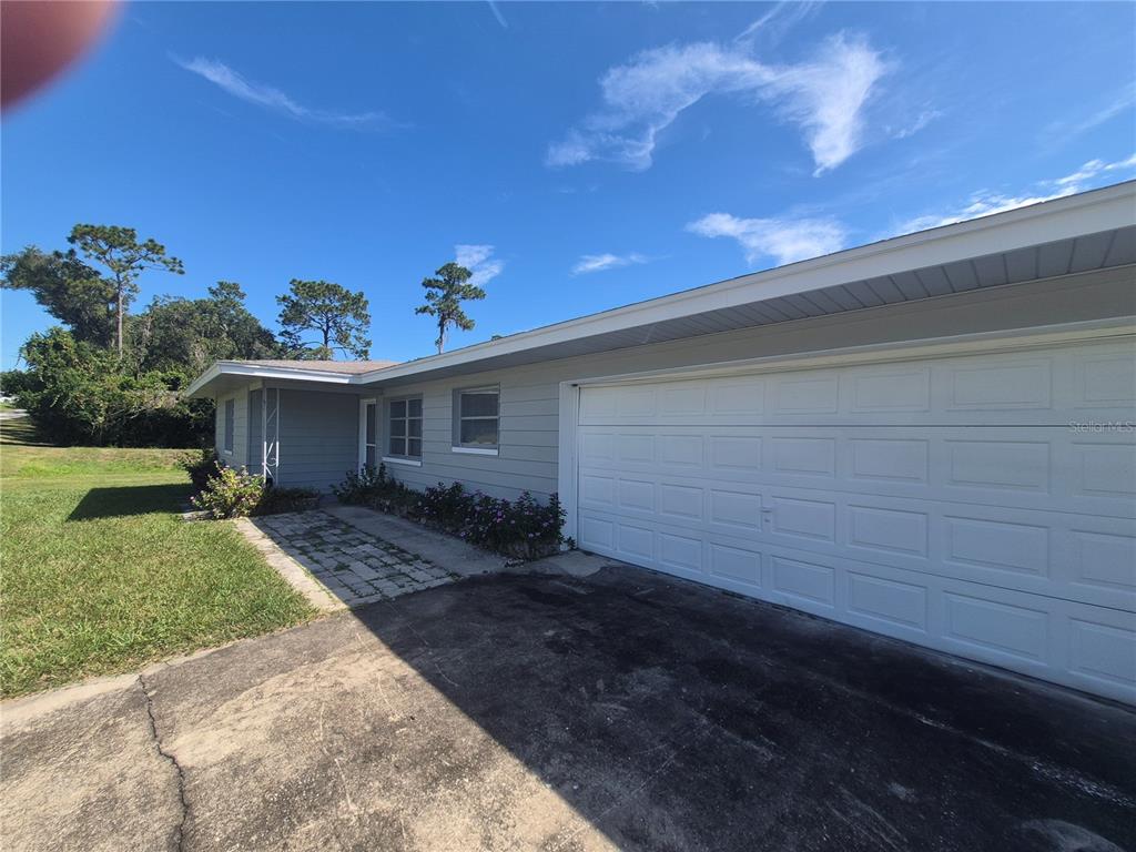 An outdoor view of a house exterior featuring a gray HVAC unit and a chain-link fence — 4333 S RAINBOW DRIVE, INVERNESS, FL