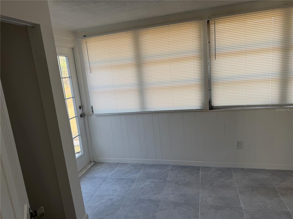 A side view of a house with gray siding, a brick walkway, and a fenced yard — 4333 S RAINBOW DRIVE, INVERNESS, FL