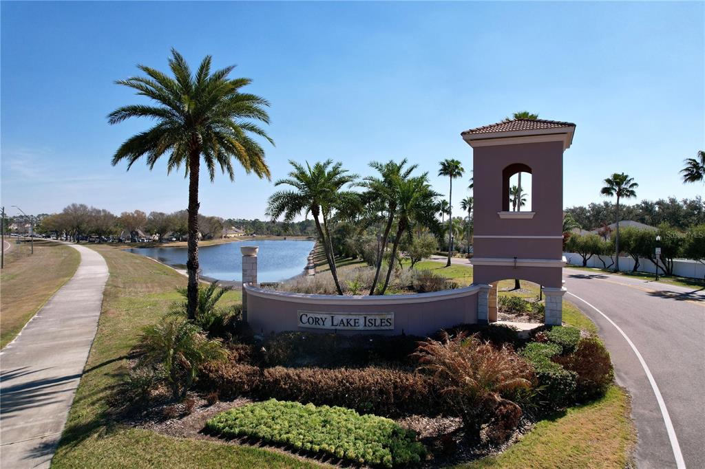 A covered front porch features a brown door with a wreath and a welcome mat — 15246 ANGUILLA ISLE AVENUE, TAMPA, FL