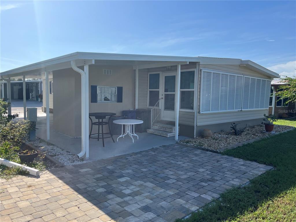A mobile home exterior features a covered patio, paved walkway, and white siding — 792 GRADO DRIVE, VENICE, FL