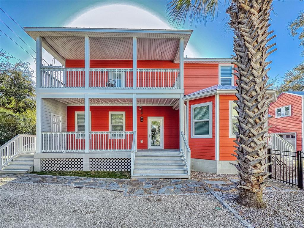 A two-story red house with a large front porch and a palm tree in front — 76 DUERO STREET, ST AUGUSTINE, FL