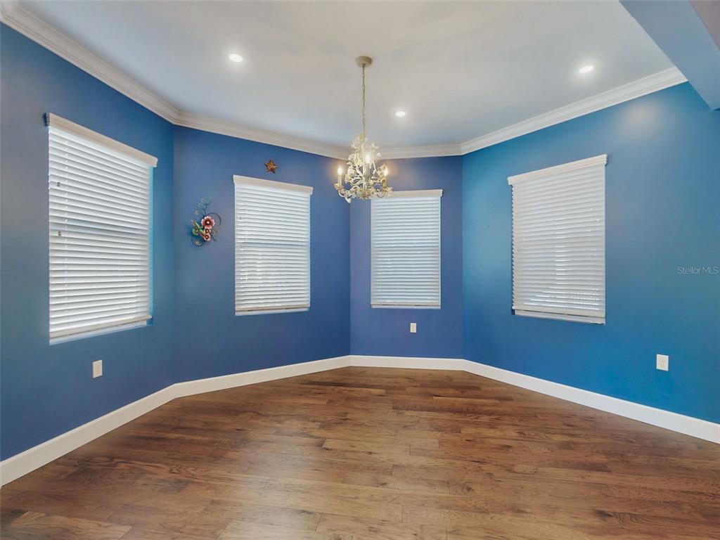 A light blue room with dark wood floors features a glass door and a window — 76 DUERO STREET, ST AUGUSTINE, FL