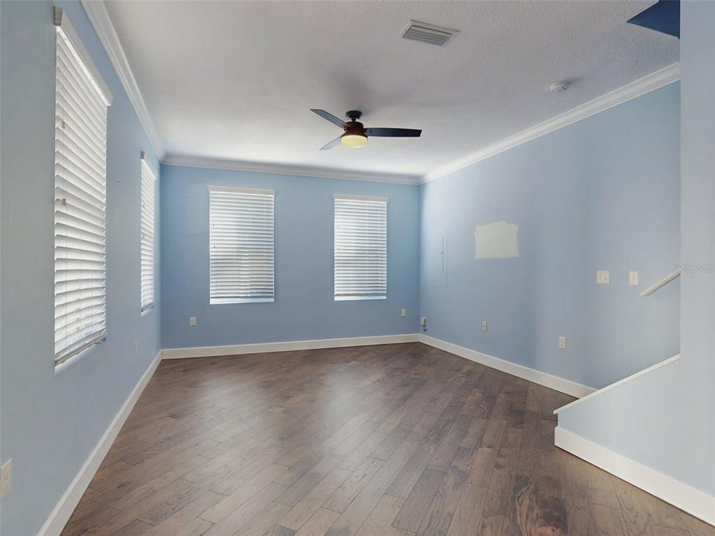A kitchen features white cabinets, a central island with wine storage, and blue walls — 76 DUERO STREET, ST AUGUSTINE, FL