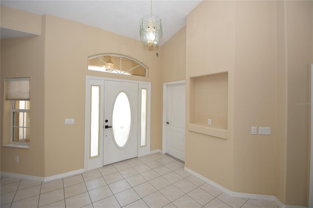 An entryway features beige walls, tiled floors, a white front door, and a recessed wall niche — 10 CRAMPTON COURT, PALM COAST, FL