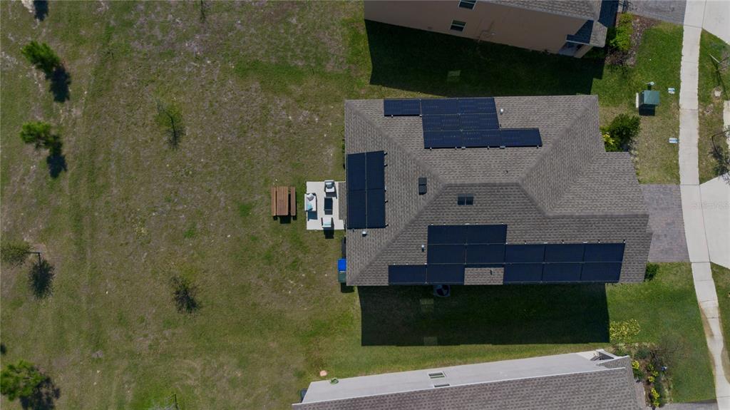 An aerial view of a house roof with solar panels and a backyard patio area — 2825 MULLER OAK LOOP, OCOEE, FL
