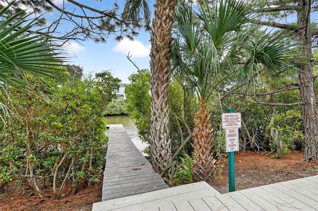 A kitchen with light wood cabinets, stainless steel appliances, and tile flooring overlooks a dining area — 14879 SEMINOLE TRAIL, SEMINOLE, FL