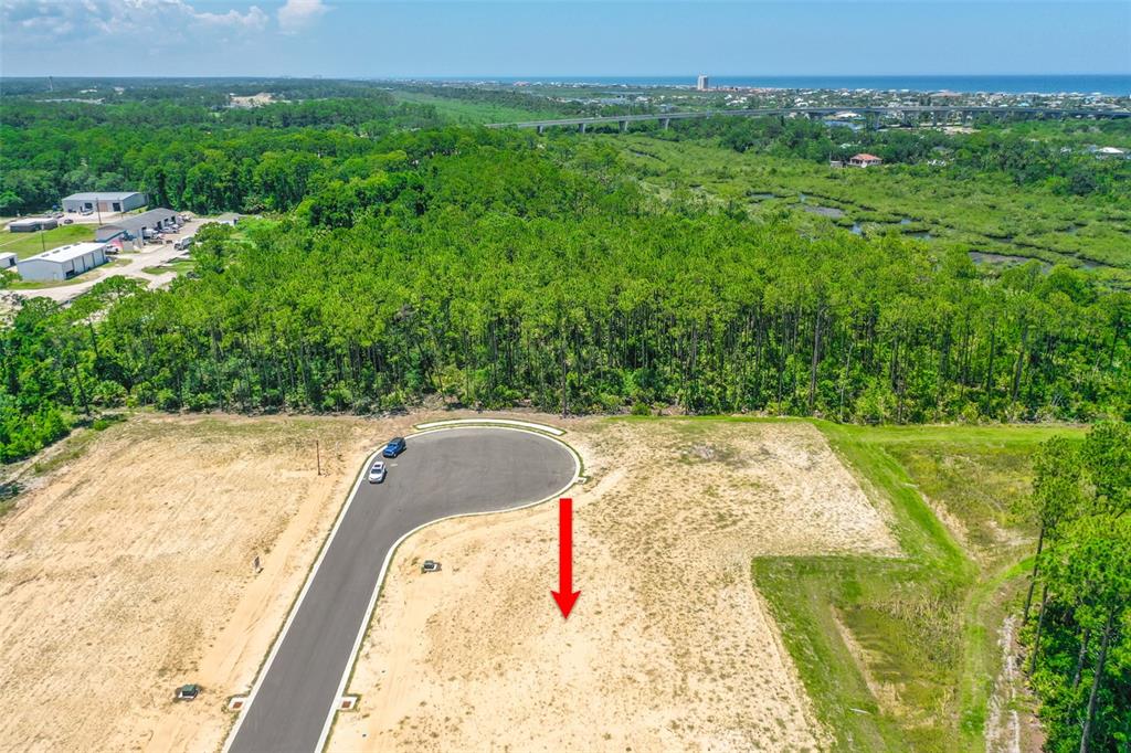 An aerial view shows a vacant, sandy residential lot at the end of a cul-de-sac — 234 STILLWATER DRIVE, FLAGLER BEACH, FL