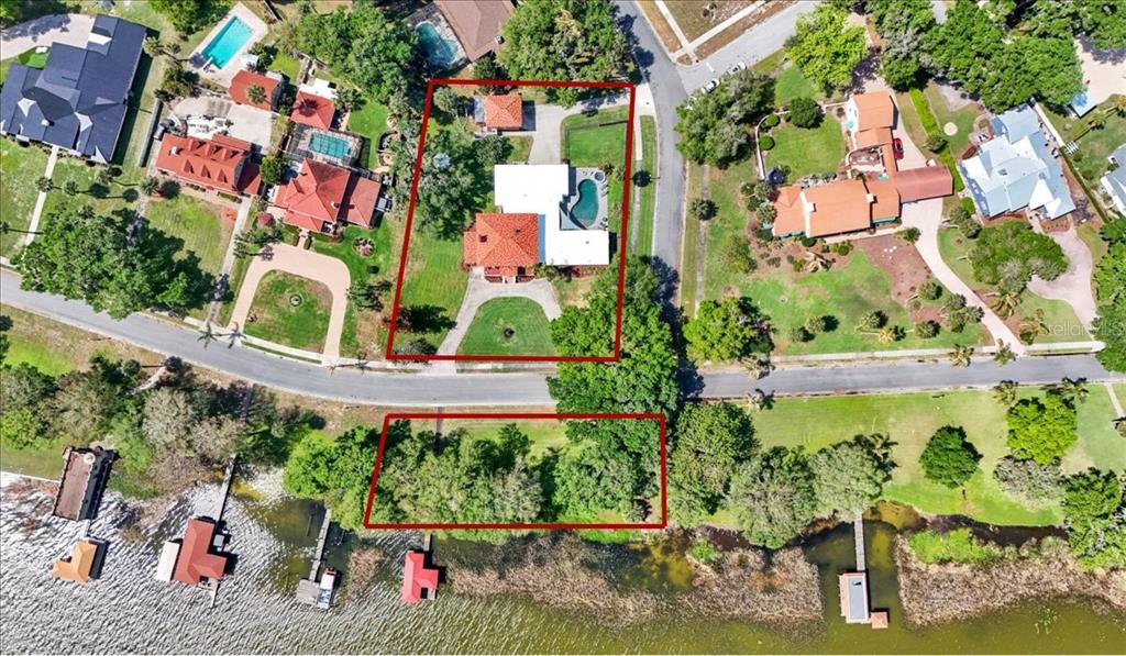 An aerial view of a boat dock with a red roof on a lake — 405 LAKESHORE DRIVE, LEESBURG, FL