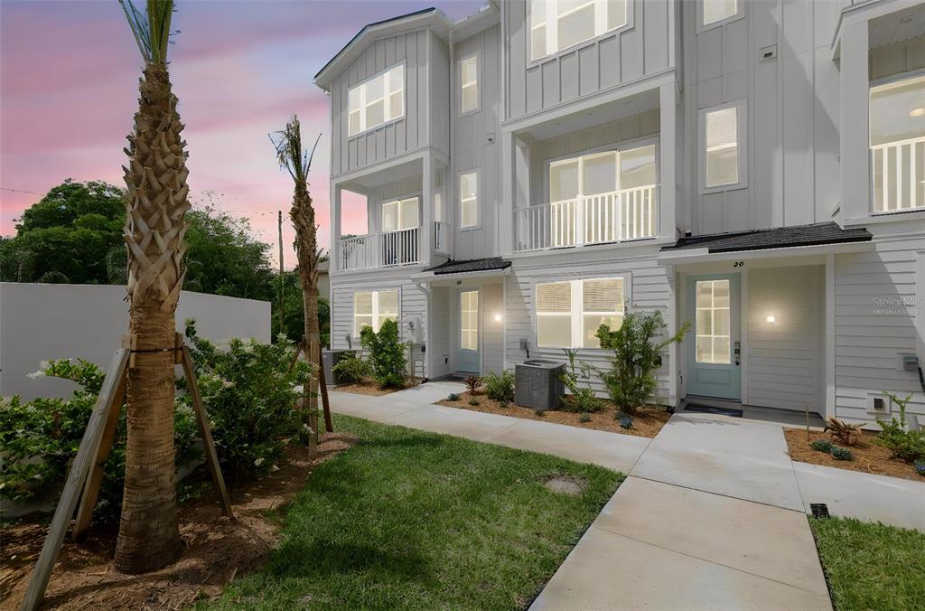 A three-story white townhouse exterior with a small front lawn and a concrete walkway — 1043 N 1ST AVENUE, JACKSONVILLE BEACH, FL