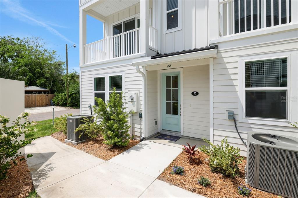 The exterior of a two-story white house features a light blue front door and landscaping — 1043 N 1ST AVENUE, JACKSONVILLE BEACH, FL