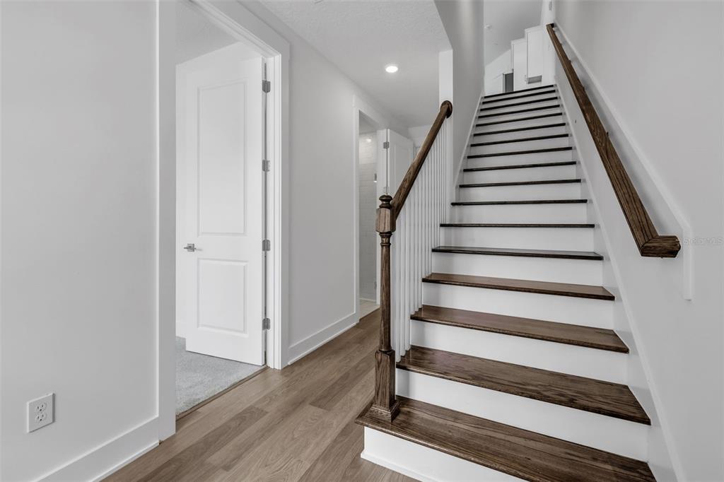 A staircase with dark wood treads and white risers leads to an upper level — 1043 N 1ST AVENUE, JACKSONVILLE BEACH, FL