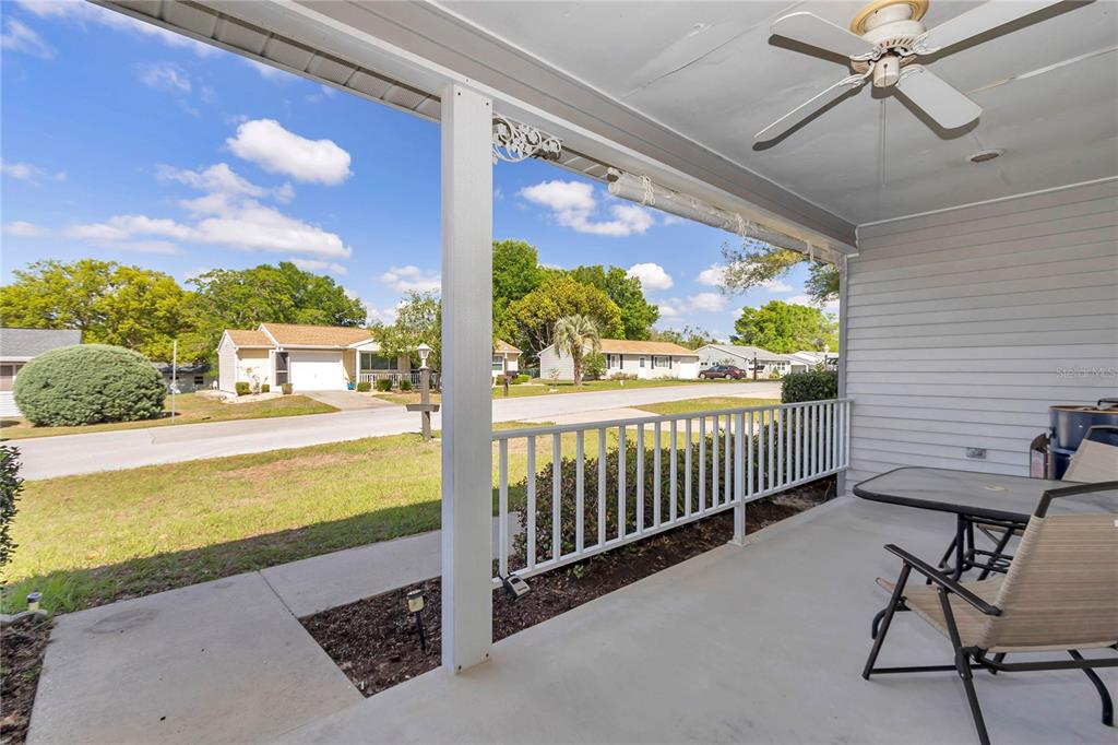 A side view of a house exterior with light siding, a sandy yard, and trees — 10891 SW 89TH AVENUE, OCALA, FL
