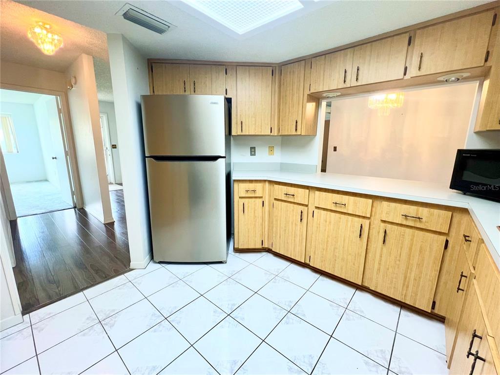 A covered porch features a ceiling fan, white railing, and a view of a suburban street — 10891 SW 89TH AVENUE, OCALA, FL