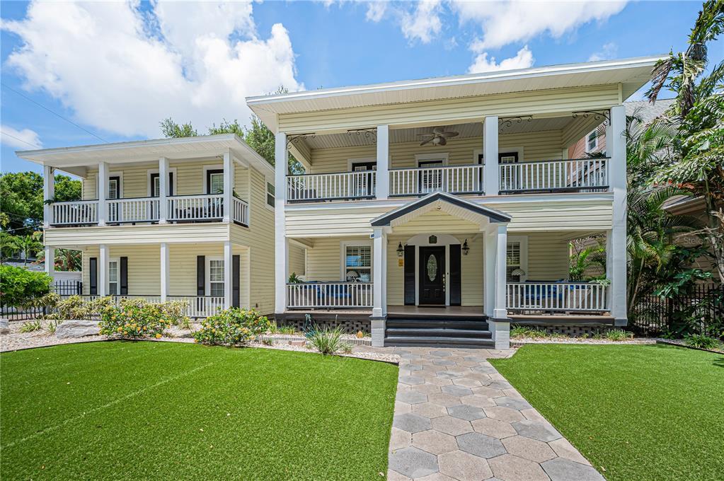 A two-story house with light yellow siding, a front porch, and a stone walkway — 732 and 732 1/2 NE OAK STREET, ST PETERSBURG, FL