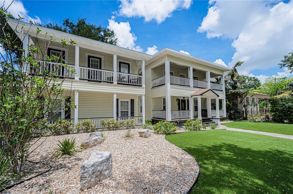 A two-story yellow house with double porches and a gravel front yard — 732 and 732 1/2 NE OAK STREET, ST PETERSBURG, FL