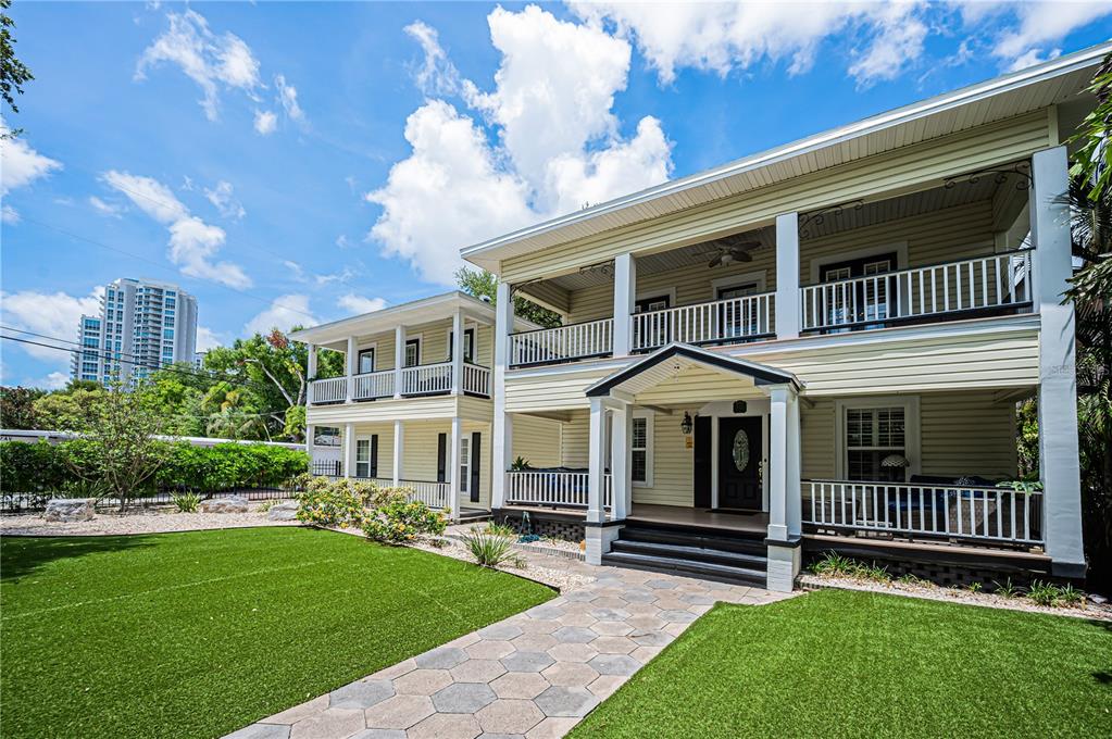 A two-story yellow house with wrap-around porches and a stone walkway across a lawn — 732 and 732 1/2 NE OAK STREET, ST PETERSBURG, FL