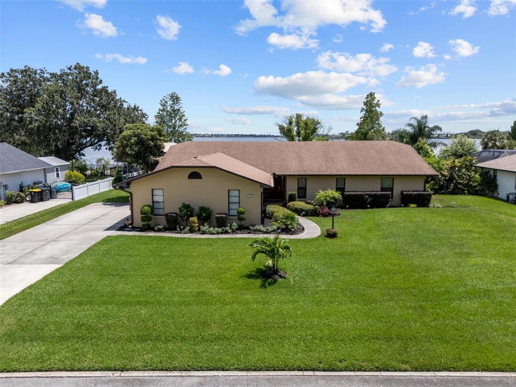 An entryway features a white front door, a storage bench with pillows, and a large mirror — 926 VAN DRIVE, AUBURNDALE, FL