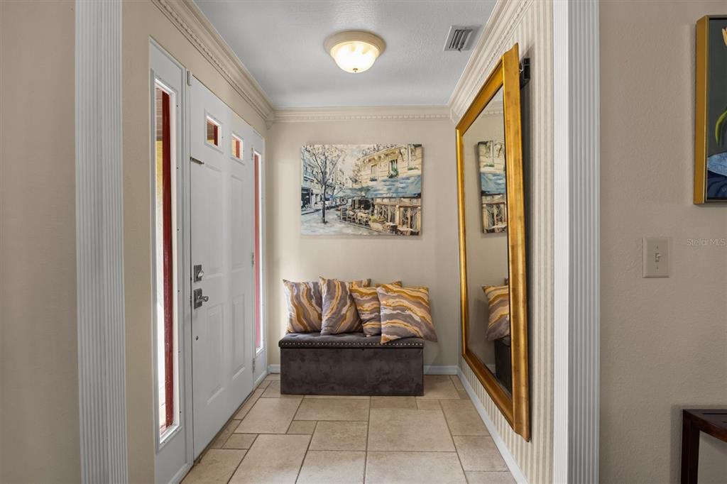 A living room with tile floors, a beige sofa, a coffee table, and sliding glass doors — 926 VAN DRIVE, AUBURNDALE, FL