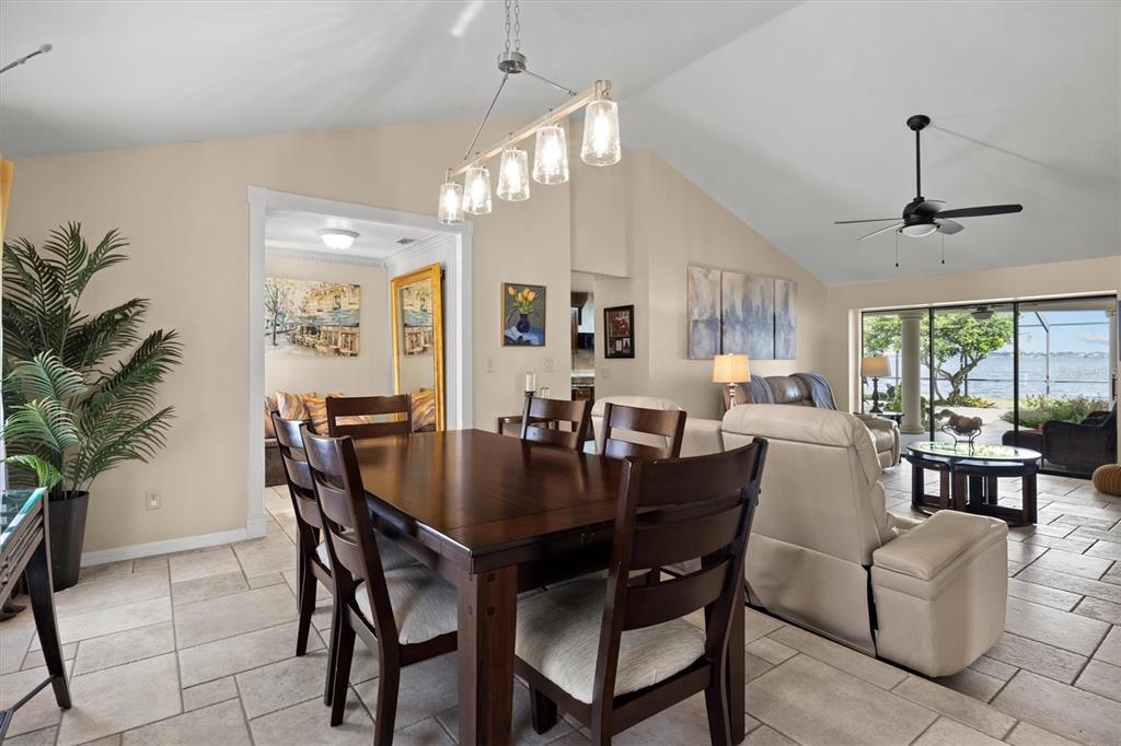 A kitchen with wood cabinets, granite countertops, tile flooring, and a view of a dining area — 926 VAN DRIVE, AUBURNDALE, FL