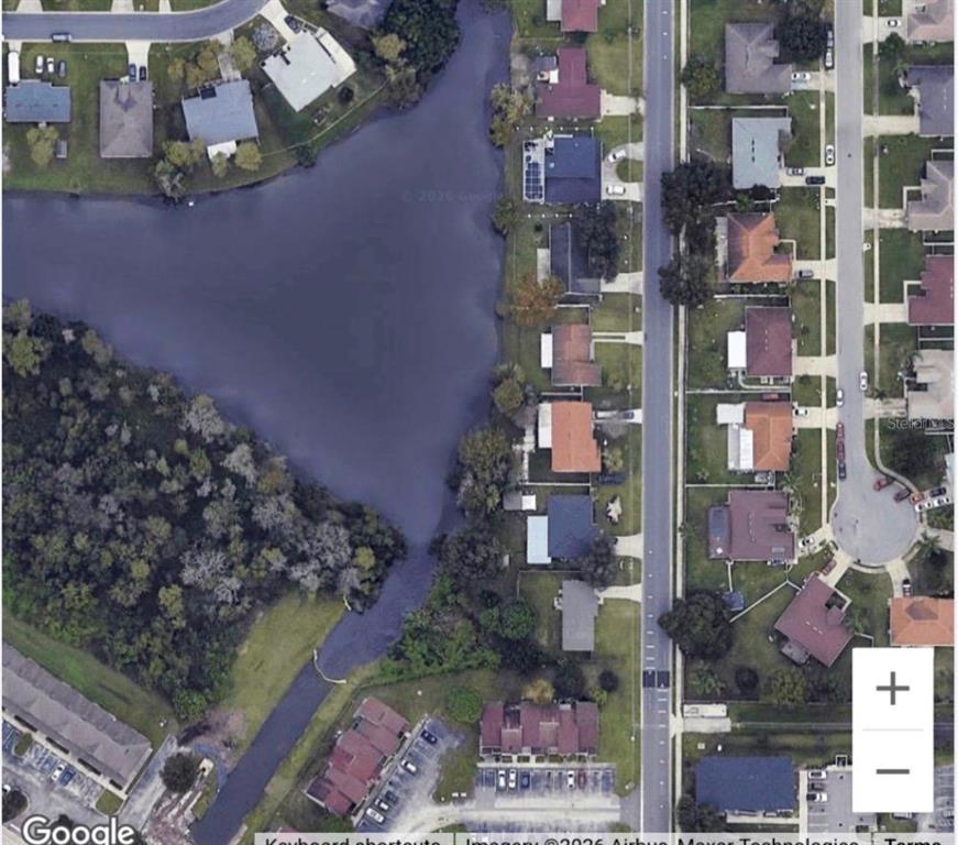 This aerial map view shows a residential neighborhood with houses bordering a large pond — 282 SEAL STREET, KISSIMMEE, FL