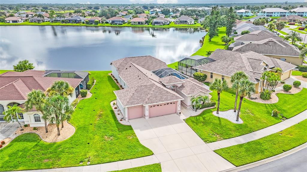 An aerial view of a suburban house with a three-car garage and a lake view — 5494 SABAL TRACE DRIVE, NORTH PORT, FL
