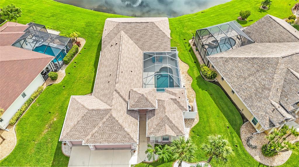 An aerial view shows a house with a screened pool and a shingled roof — 5494 SABAL TRACE DRIVE, NORTH PORT, FL
