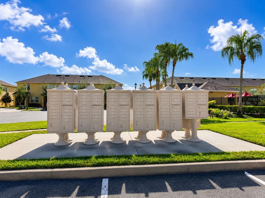 A row of beige metal cluster mailboxes stands on a concrete pad outdoors — 9174 TECUMSEH DRIVE, ORLANDO, FL