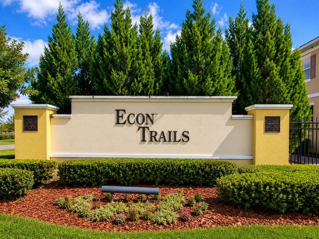 A beige monument sign for Econ Trails stands in front of tall green trees — 9174 TECUMSEH DRIVE, ORLANDO, FL