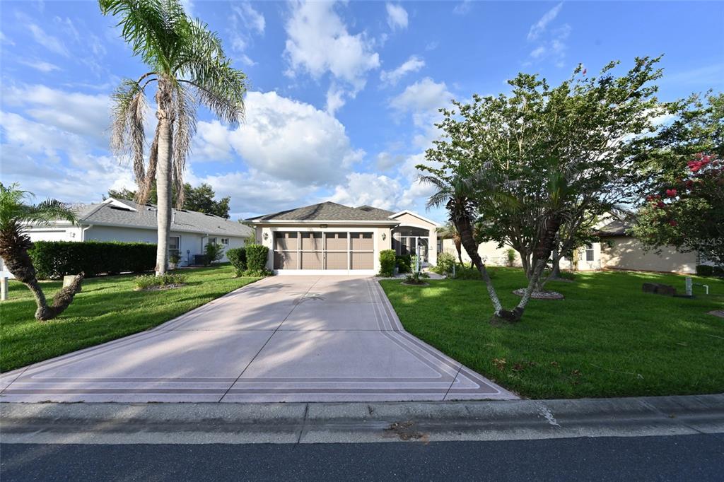 A single-story house with a beige garage and two prominent palm trees in the front yard — 27326 ORCHID GLADE STREET, LEESBURG, FL