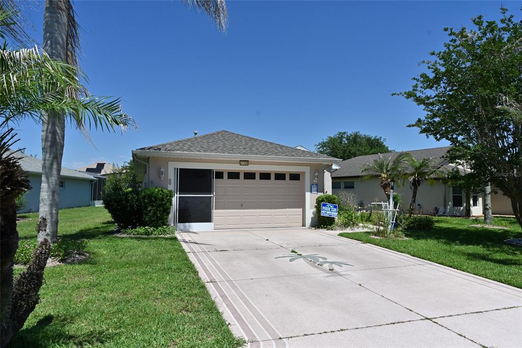 A kitchen features white cabinets, stainless steel appliances, tile flooring, and a large floral centerpiece — 27326 ORCHID GLADE STREET, LEESBURG, FL
