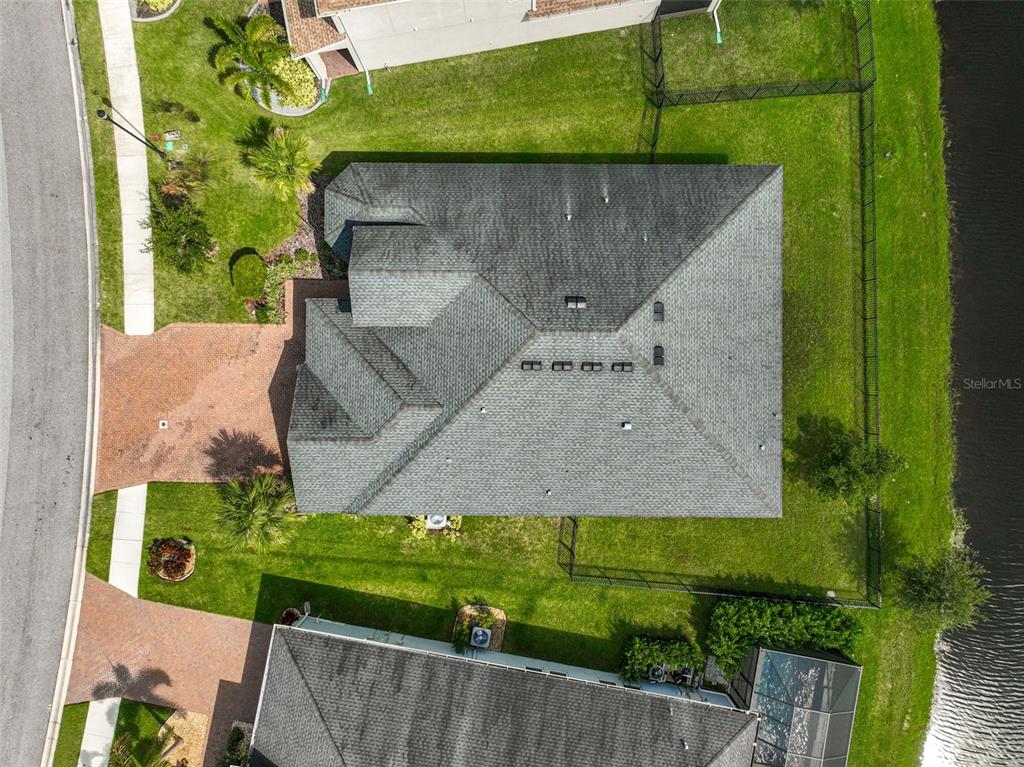 An aerial view shows a single-family home with a gray shingled roof and brick driveway — 5514 69TH PLACE E, ELLENTON, FL