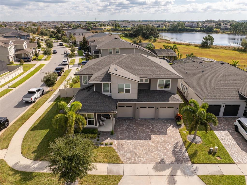 An aerial view of a two-story suburban house with a three-car garage and driveway — 16894 WINGSPREAD LOOP, WINTER GARDEN, FL