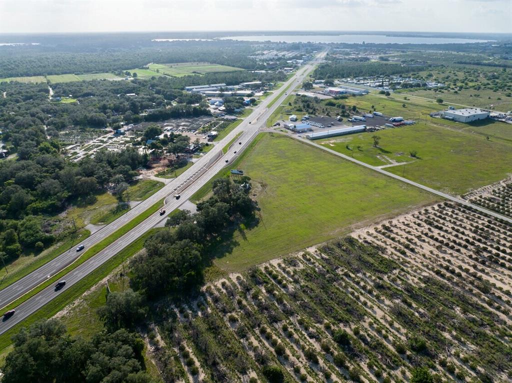 An aerial view shows a highway running through a rural landscape with fields and trees — 4906 US HIGHWAY 27 S, SEBRING, FL