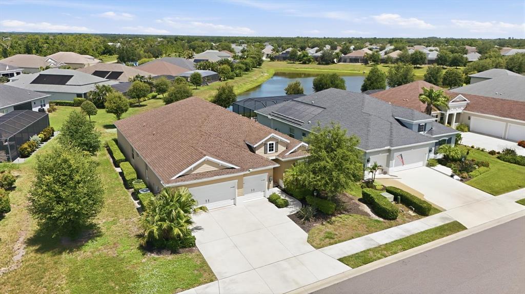 An aerial view shows two suburban houses with garages and driveways near a small pond — 1109 THORNBURY DRIVE, PARRISH, FL