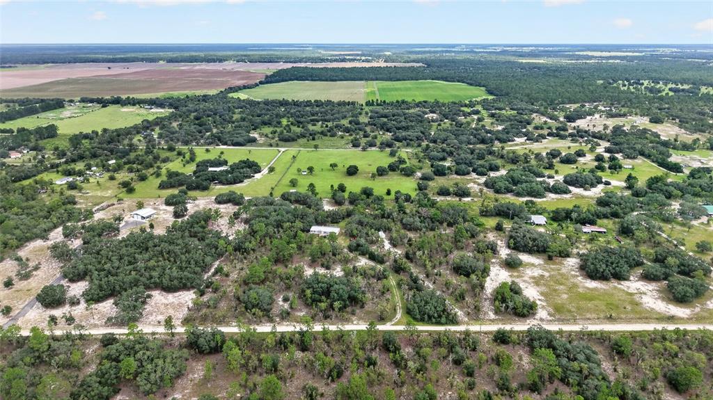 An aerial view shows a rural landscape with scattered houses, trees, and open fields — 13291 SE 101ST PLACE, DUNNELLON, FL