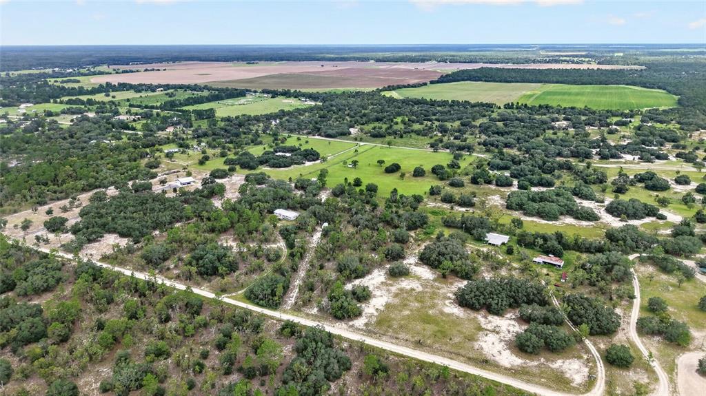An aerial view shows a rural landscape with scattered houses, trees, and dirt roads — 13291 SE 101ST PLACE, DUNNELLON, FL