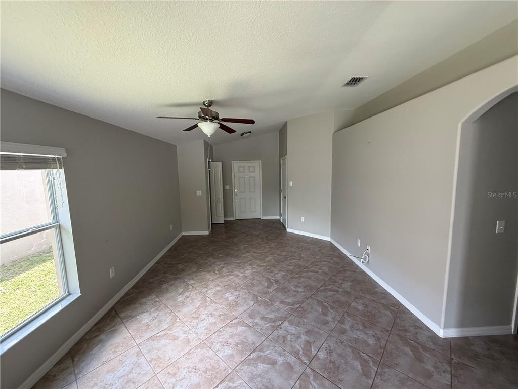An empty room features beige walls, tile flooring, a ceiling fan, and a front door — 1970 HAWKS VIEW DRIVE, RUSKIN, FL