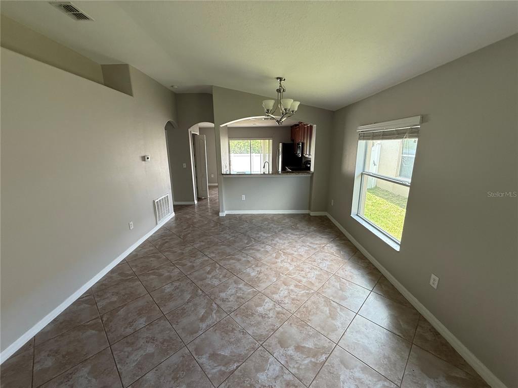A dining area with tile flooring, a chandelier, and an open view into the kitchen — 1970 HAWKS VIEW DRIVE, RUSKIN, FL