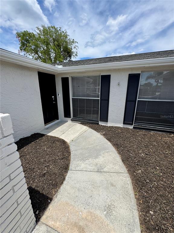 A single-story house with a white garage and a palm tree in the front yard — 6135 SEABREEZE DRIVE, PORT RICHEY, FL