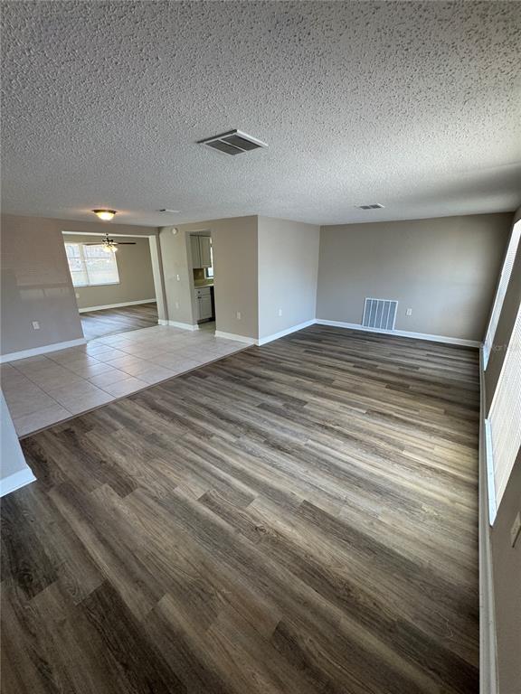A concrete walkway leads to a black front door beside two windows with black shutters — 6135 SEABREEZE DRIVE, PORT RICHEY, FL